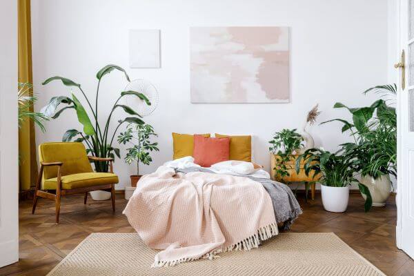 Great Colour Ideas To Transform Your Bedroom 3 Lots of green in a white bedroom including plants and armchairs