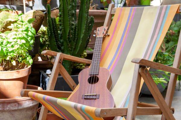 A bright coloured deck chair with a small guitar on it