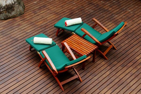 A sun lounger with green cushions
