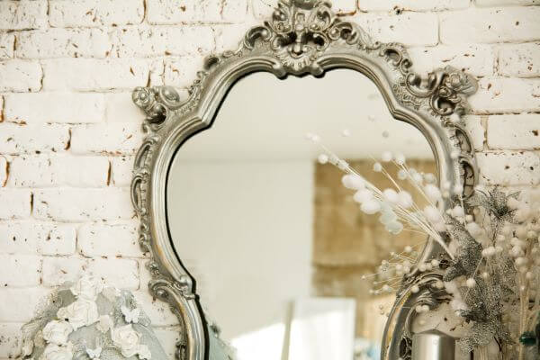 A vintage mirror in a white bathroom