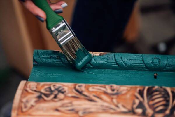 A person who upcycle that recycled bit of furniture with a lick of paint