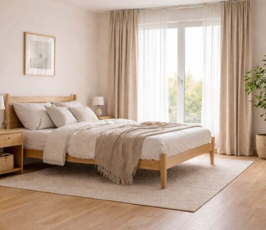 Scandinavian-style small double bedroom with oak bed frame, neutral bedding and light-filled minimalist design